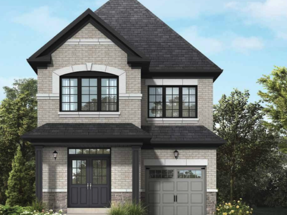 A two-story house with a pointed roof, brick exterior, and large windows. The garage is on the right, and the entrance is on the left with a small porch. The front yard boasts green grass and bushes beneath a clear blue sky—a perfect example of new homes in Brampton.