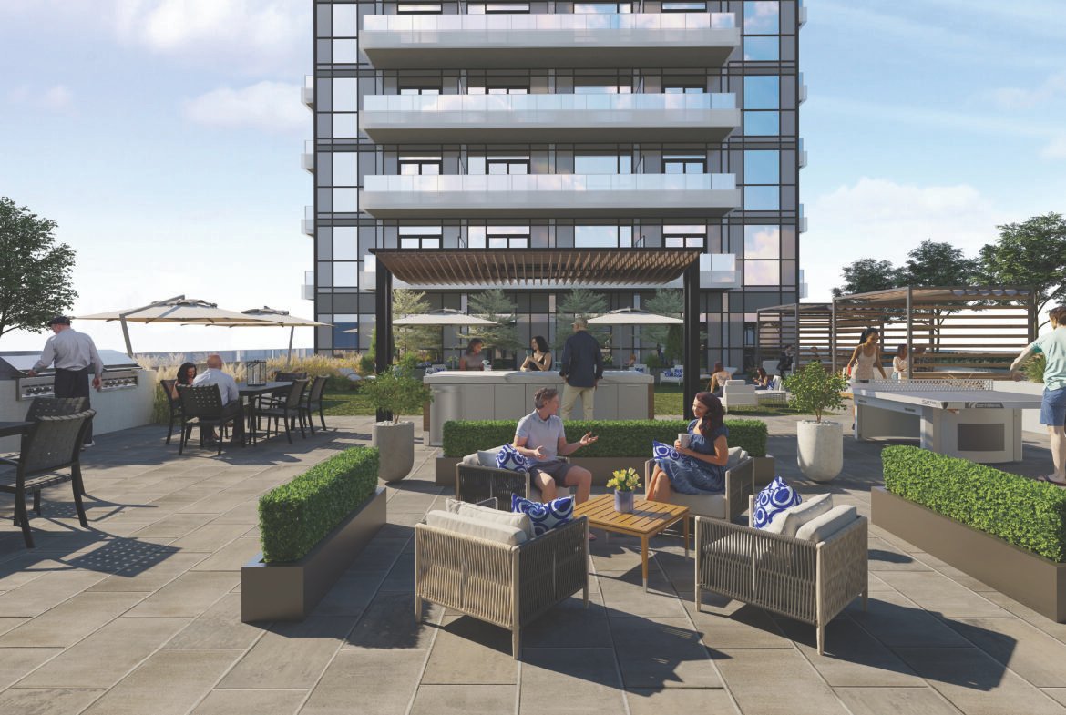 The rooftop terrace offers a lively space with people relaxing on patio furniture amidst lush plants. A modern building adds to the backdrop, while colorful umbrellas and tables dot the scene. The bright atmosphere showcases a clear sky, perfect for enjoying views of new condos in GTA.