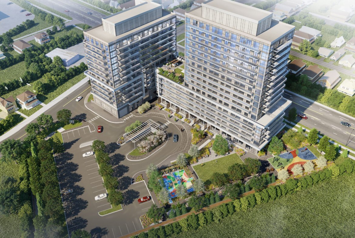 Aerial view of a modern building complex with two tall, adjacent structures and a curved entrance driveway. The area includes a playground, landscaped greenery, and a parking lot, surrounded by roads and residential houses showcasing new homes in Brampton.