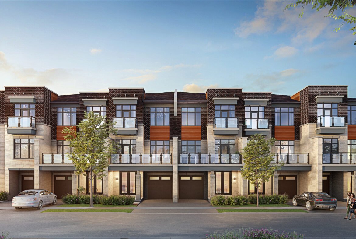 A modern three-story townhouse complex with large windows and balconies features a mix of stone and wood accents. Three cars are parked in front, and a few trees line the street under a clear blue sky. Discover pre-construction homes that offer style and comfort in this picturesque setting.