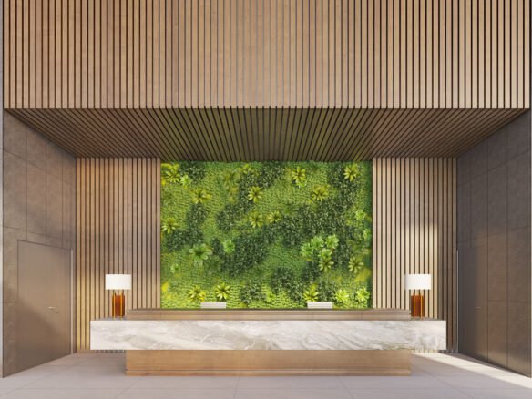 Experience the elegance of new homes with a modern lobby featuring a large green plant wall behind a marble reception desk. The architecture includes wooden panels and sculptures on gray walls, while two lamps with white shades add to the minimalist atmosphere.
