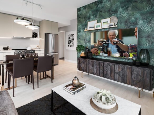 Discover modern elegance in this open-plan kitchen and living area, perfect for new homes in Toronto. It features sleek white cabinets, stainless steel appliances, and a dining table. The living room boasts a green accent wall, TV, decorative wooden console items, and a welcoming coffee table with plants.