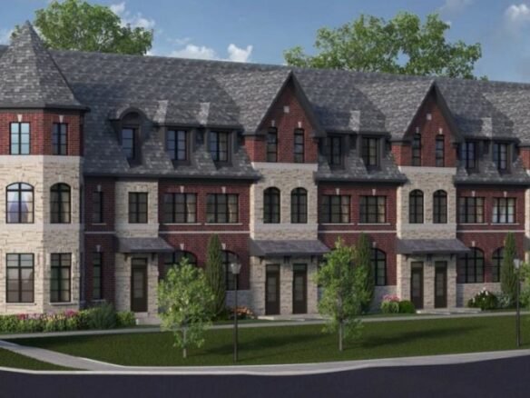 A row of elegant townhouse-style buildings with red brick and stone facades, featuring large windows and peaked roofs. Trees and neatly manicured lawns line the sidewalk in front of the buildings under a partly cloudy sky, embodying the charm of new homes in Toronto.