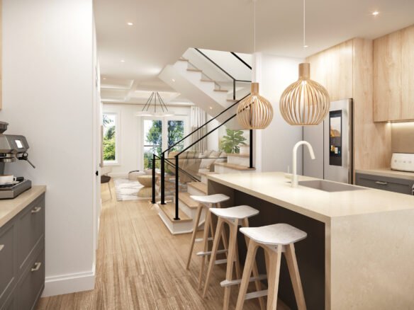 Discover a modern kitchen in new homes in Toronto, featuring light wood accents and a large island with three stools. Stylish pendant lights hang above. A staircase leads to a bright living area with cozy seating. Brown cabinets and a coffee machine are on the left, creating warmth and convenience.
