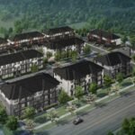 Aerial view of a residential neighborhood featuring new homes in the GTA with rows of modern, multi-story buildings surrounded by trees. A main road runs along the front with cars visible, alongside well-planned green spaces and parking lots.