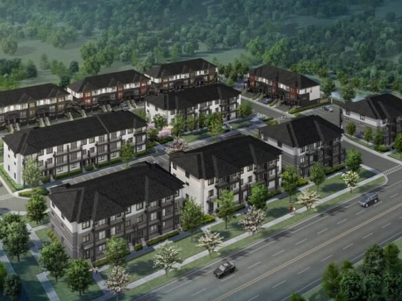 Aerial view of a residential neighborhood featuring new homes in the GTA with rows of modern, multi-story buildings surrounded by trees. A main road runs along the front with cars visible, alongside well-planned green spaces and parking lots.