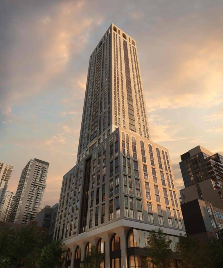 101 Spadina Condos A tall, modern skyscraper with a sleek design stands prominently against a sunset sky, part of the Toronto Real Estate landscape. The building's facade features large windows and geometric patterns. Nearby, other high-rise buildings are visible, and trees are in the foreground.