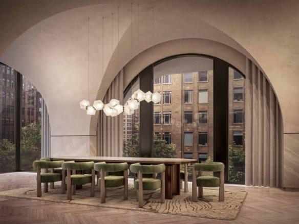 A modern dining room at 101 Spadina Condos features an arched ceiling and large windows with city views. A wooden dining table is surrounded by green upholstered chairs, and contemporary pendant lights hang above it. The room boasts a herringbone wood floor and a beige color scheme.