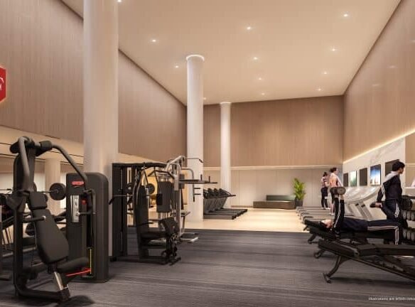 In a modern gym interior nestled within new condos, exercise machines, free weights, and treadmills buzz with activity. High ceilings and warm lighting accentuate the spaciousness, while a large wall mirror captures the energetic environment of residents dedicated to fitness.