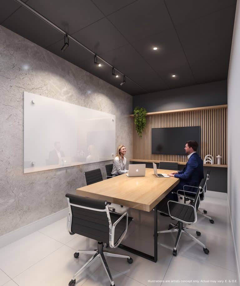 In a modern office meeting room with a long wooden table and four black chairs, two people sit with laptops facing each other. The room features a whiteboard on a textured wall and vertical plant decor. Ceiling lights illuminate the space, reminiscent of sleek designs found in new condos. In a modern office meeting room with a long wooden table and four black chairs, two people sit with laptops facing each other. The room features a whiteboard on a textured wall and vertical plant decor. Ceiling lights illuminate the space, reminiscent of sleek designs found in new condos.