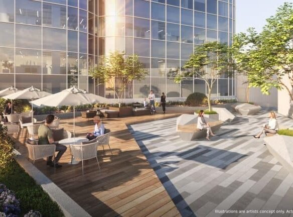 A rooftop terrace overlooks a modern glass facade, where people sit and chat at umbrella-covered tables. The space features wooden decking, gray paving, and planters with trees and shrubs—a perfect spot for residents of new homes in GTA to unwind.