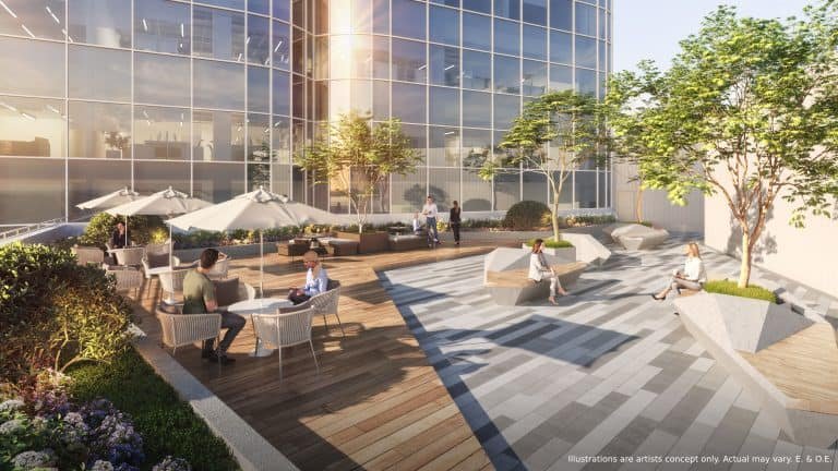 A rooftop terrace overlooks a modern glass facade, where people sit and chat at umbrella-covered tables. The space features wooden decking, gray paving, and planters with trees and shrubs—a perfect spot for residents of new homes in GTA to unwind.