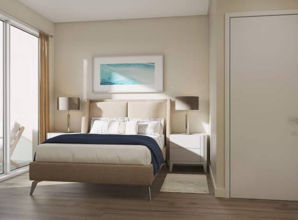 A modern bedroom in the new homes of GTA features a large bed with white and navy bedding. Two matching bedside tables with lamps flank the bed. A seascape painting graces the wall, and to the left, a glass door opens to a balcony with inviting outdoor seating.