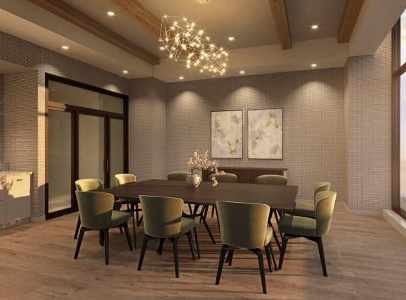 A modern dining room in SG Homes features a long wooden table surrounded by green cushioned chairs. A chandelier hangs above, while large windows provide stunning city and sunset views. Two abstract paintings adorn a textured wall, perfectly complementing the elegance of new homes in the GTA.