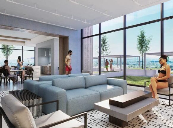 Modern lounge in new condos with blue sofas and a patterned rug. People relax and socialize inside and on the sunlit terrace, which features pergolas and a skyline view. Large floor-to-ceiling windows provide natural light and outdoor scenery, enhancing the allure of new homes in the GTA.