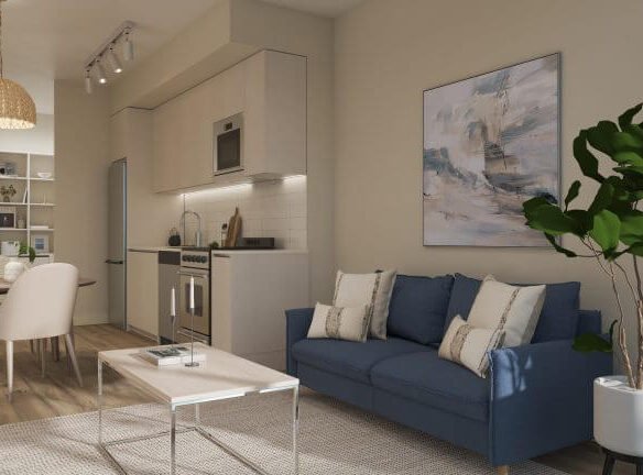 A modern living room and kitchen area in a new condo showcases a blue sofa, throw pillows, a plant, and a light wooden coffee table. The sleek kitchen features white cabinets and stainless steel appliances. A dining table with chairs complements the space, highlighted by abstract wall art.