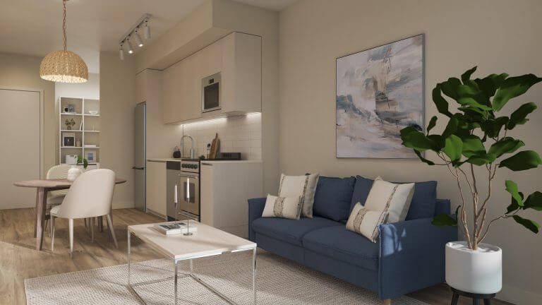 A modern living room and kitchen area in a new condo showcases a blue sofa, throw pillows, a plant, and a light wooden coffee table. The sleek kitchen features white cabinets and stainless steel appliances. A dining table with chairs complements the space, highlighted by abstract wall art.