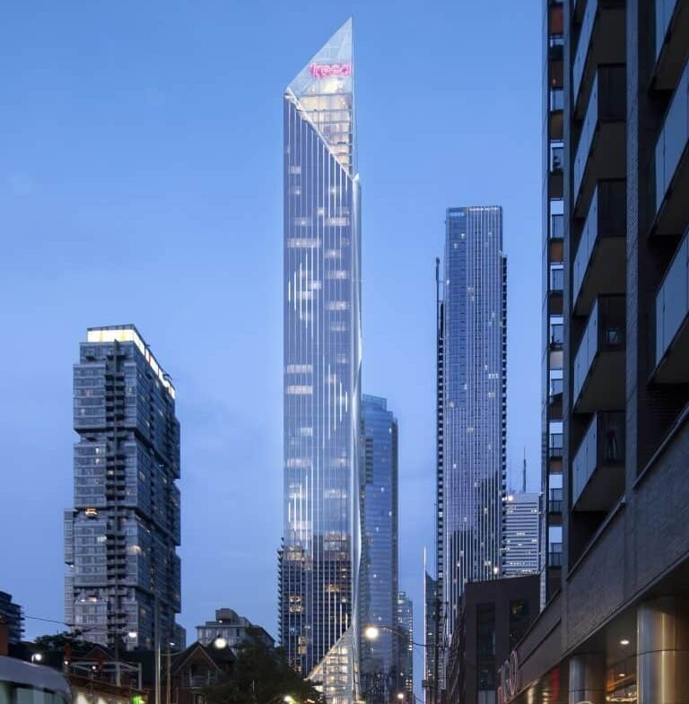 A futuristic cityscape at dusk features the Freed Hotel, an angular skyscraper with a glowing red logo at the top. The streets are wet from rain, reflecting colorful city lights. People, including a couple holding hands, walk along the sidewalk near sleek residences.