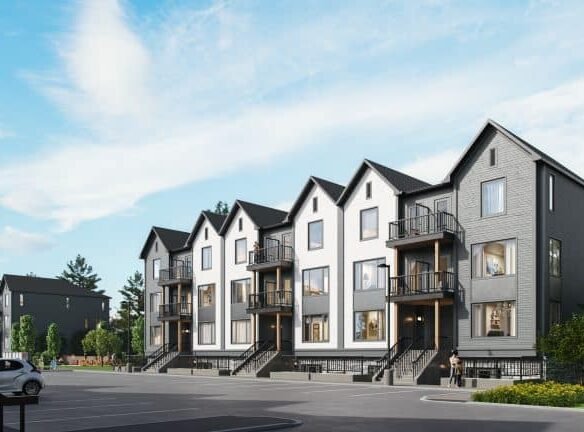 A row of modern, three-story townhouses designed by SG Homes stands with gabled roofs and large windows. The buildings, painted in neutral colors, overlook a mostly empty parking lot with a few cars. Under the clear blue sky, these pre-construction homes exude contemporary charm.