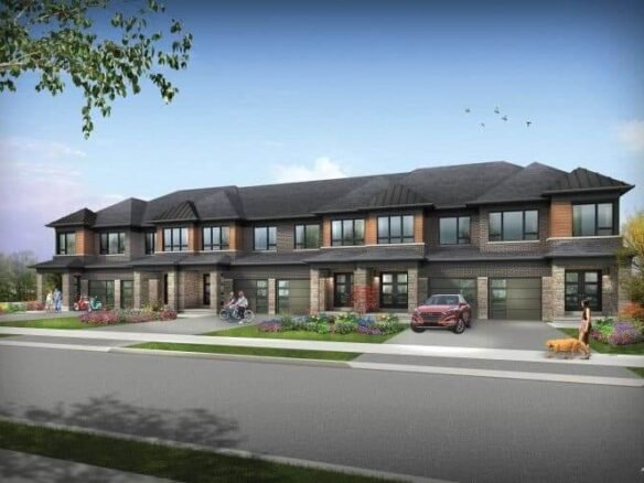 A row of modern townhouses by SG Homes showcases brown brick and dark roofs. A car is parked in front, people are out walking or biking, and someone walks a dog. Lush landscaping with flowers and trees lines the street under a clear blue sky.