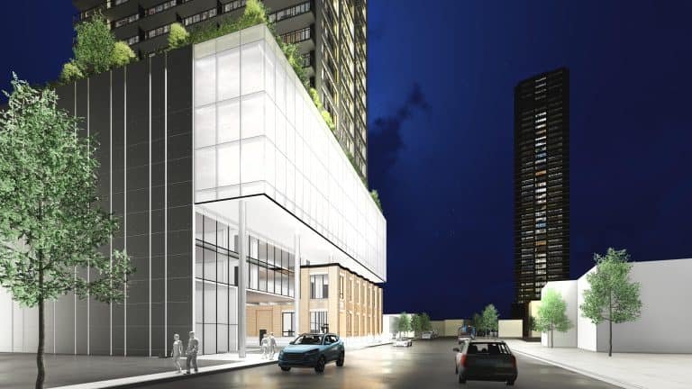 A nighttime view of a modern city street showcases tall buildings in the foreground. A glass-paneled structure with rooftop plants hints at new condos, as two cars glide along the street. Pedestrians stroll nearby, while another towering building stands proudly in the background. A nighttime view of a modern city street showcases tall buildings in the foreground. A glass-paneled structure with rooftop plants hints at new condos, as two cars glide along the street. Pedestrians stroll nearby, while another towering building stands proudly in the background.