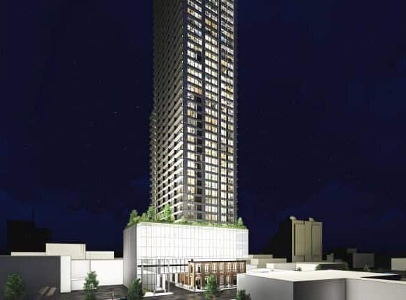 A tall, illuminated skyscraper rises against a dark night sky. The building features a modern design with a glass facade and several floors of glowing windows, resembling the sleek style often seen in new homes in GTA. Surrounding the structure are low-rise buildings and trees.