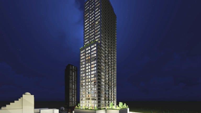 Night view of a tall, illuminated skyscraper with numerous lit windows surrounded by smaller buildings. The clear, dark sky enhances the building’s lights, while new condos rise alongside. Trees frame the base of this modern marvel, offering a glimpse into urban living at its finest. Night view of a tall, illuminated skyscraper with numerous lit windows surrounded by smaller buildings. The clear, dark sky enhances the building's lights, while new condos rise alongside. Trees frame the base of this modern marvel, offering a glimpse into urban living at its finest.