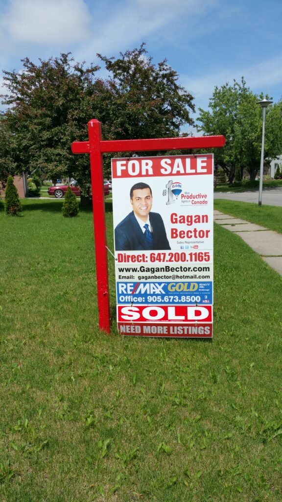 A for sale sign in front of a house.