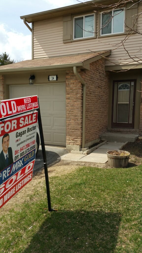 A for sale sign in front of a house.