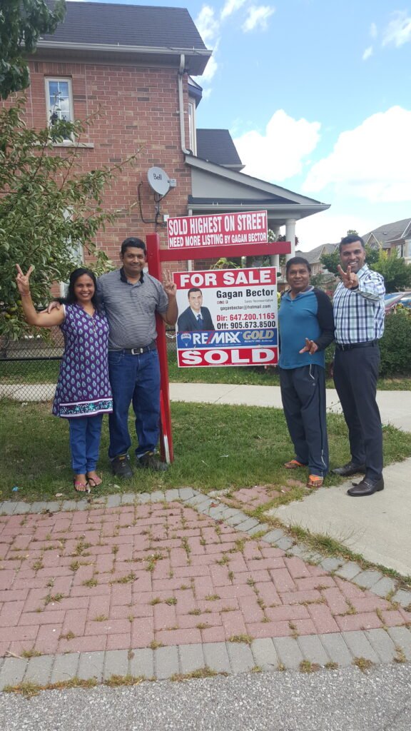 A group of people standing in front of a house.