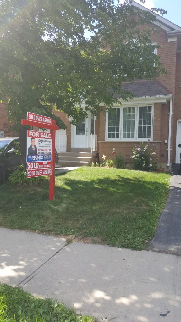 A house with a sign in front of it.