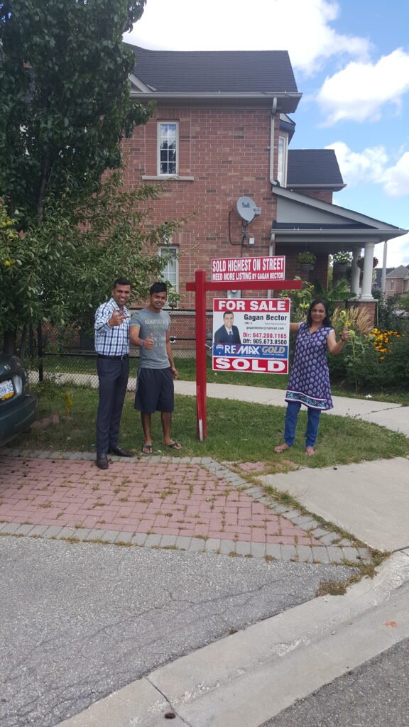 A group of people standing in front of a house.
