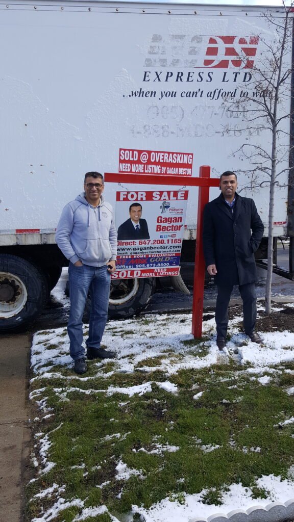 Two men standing in front of a truck.