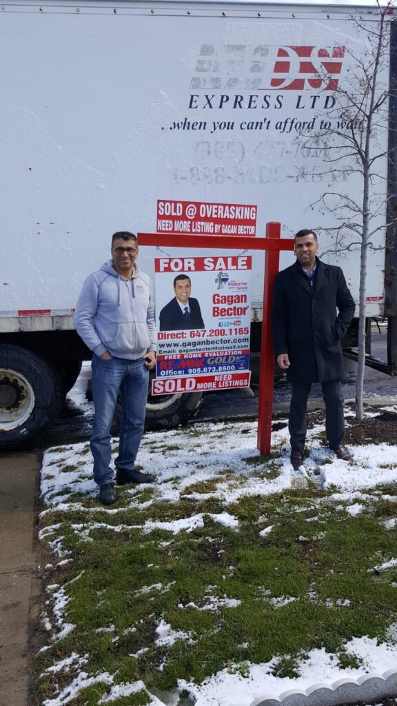 Two men standing in front of a truck.