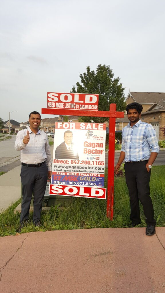 Two men standing next to a sign.