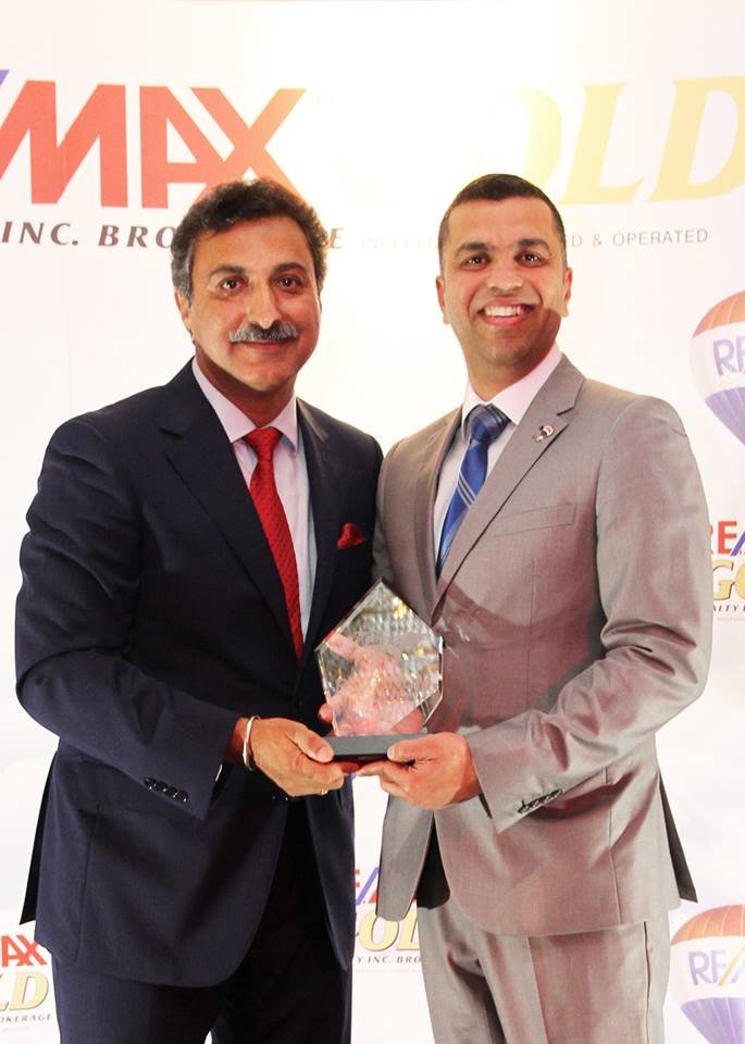 Two men standing next to each other holding an award.