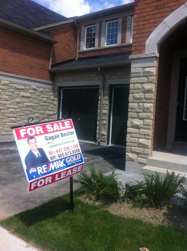 A for sale sign in front of a house.