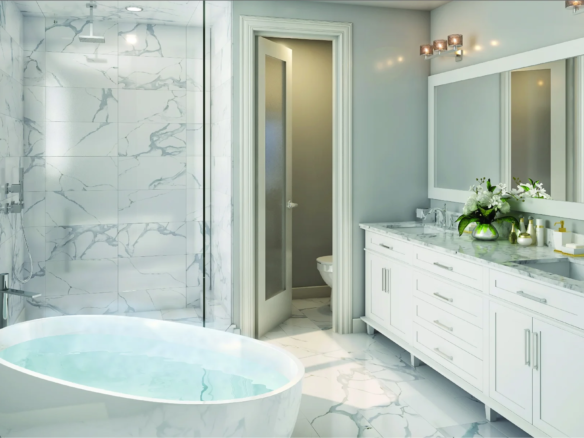 Modern Caledon Club bathroom featuring a freestanding tub filled with water, marble floors and walls, large mirror above double sink vanity, glass shower, and a door to the toilet area. White and light gray tones with stylish lighting complete the look.