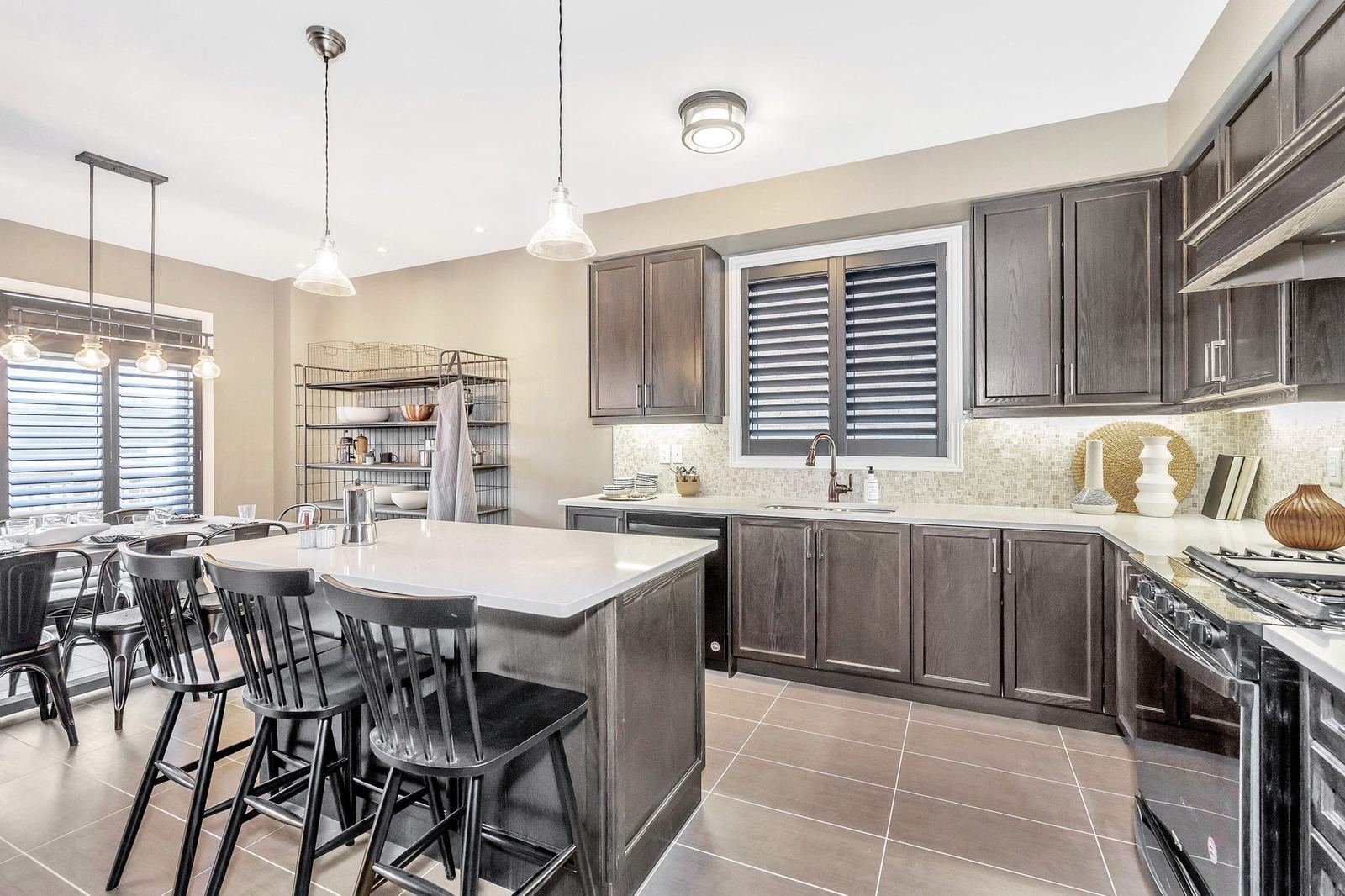 Modern kitchen and adjoining family dining area in the Enchant model home at Empire Legacy