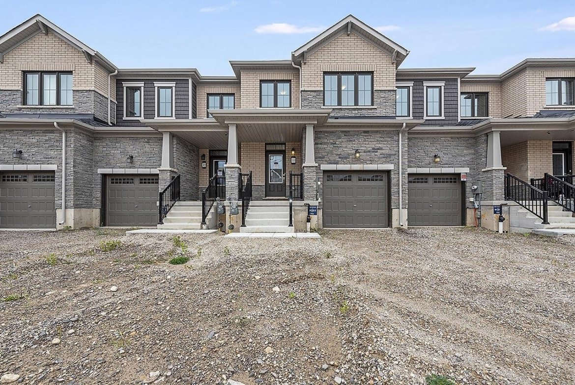 Sunlit open-concept living space with hardwood flooring and expansive windows at Empire Riverland
