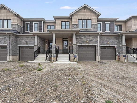 Sunlit open-concept living space with hardwood flooring and expansive windows at Empire Riverland