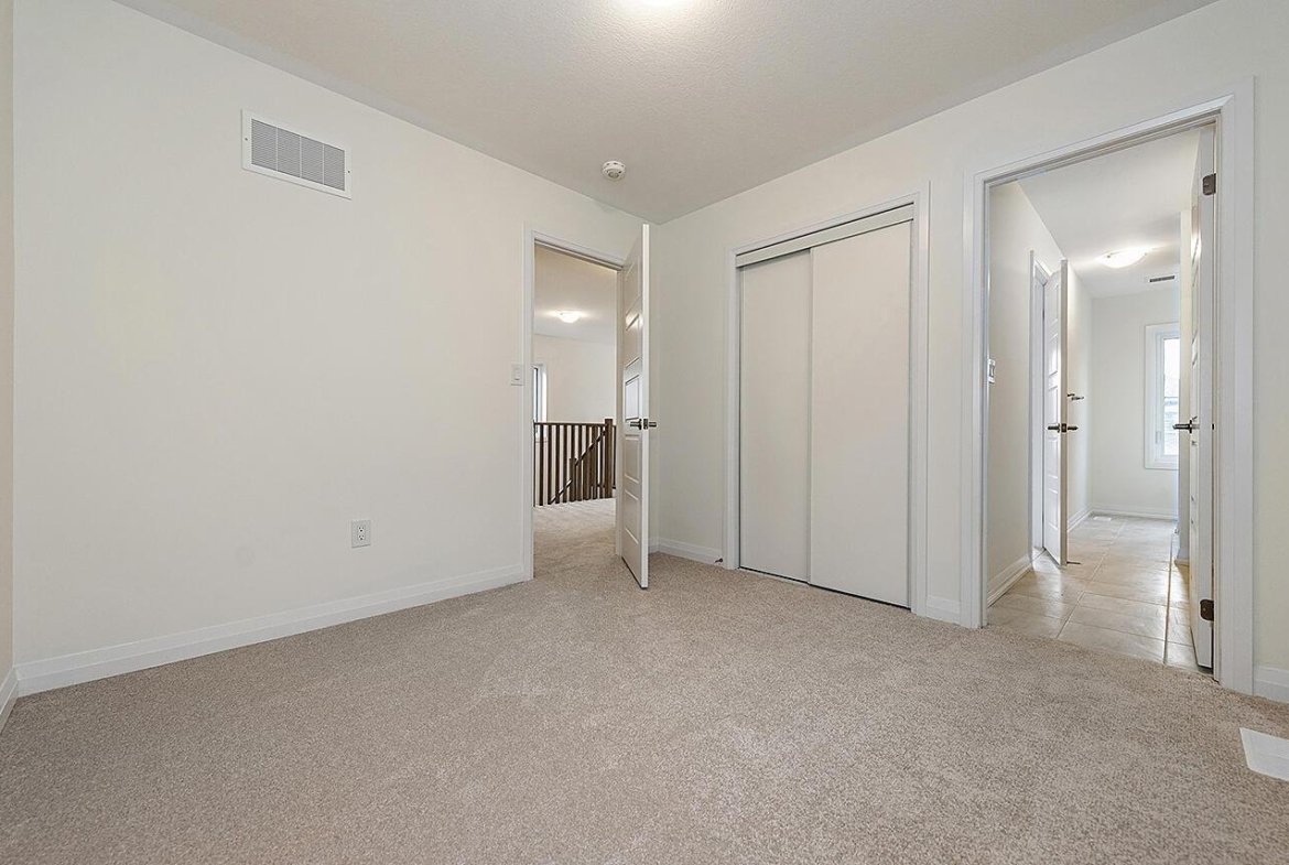 Spacious primary bedroom suite with large windows at Empire Riverland