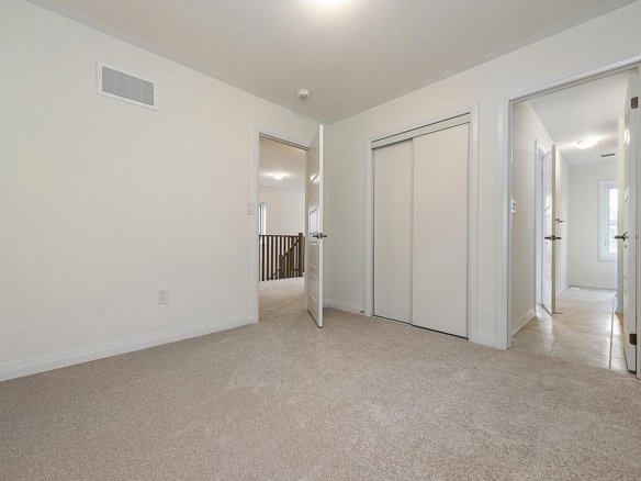 Spacious primary bedroom suite with large windows at Empire Riverland